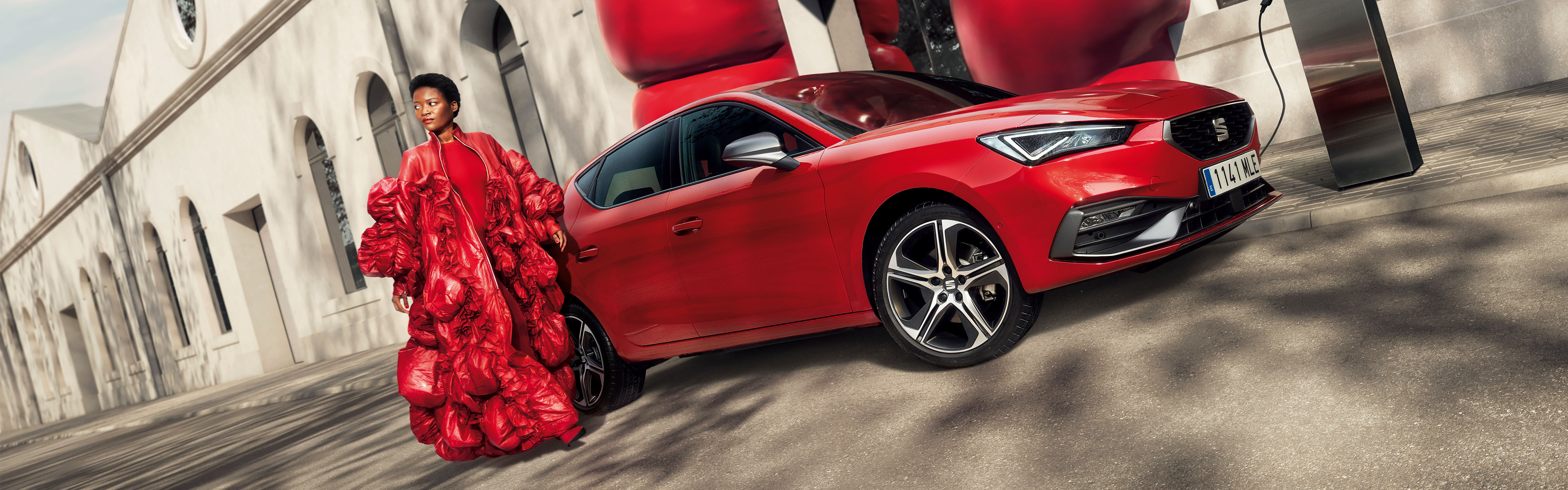 New SEAT Leon plug-in hybrid with model in a red dress and red balloons